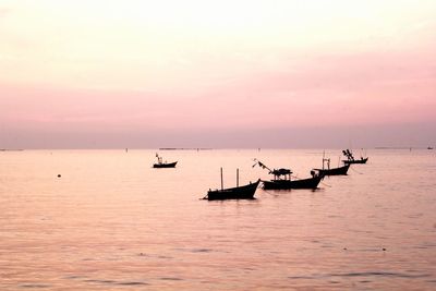 Silhouette boat in sea against sky during sunset