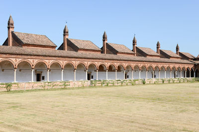 Historic building on field against clear sky