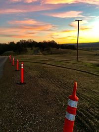 Red flag on landscape against sky during sunset