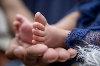 Close-up of mother holding baby while sleeping on bed at home