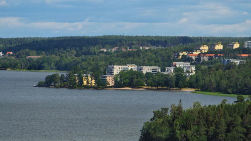 Scenic view of river and houses in town against sky