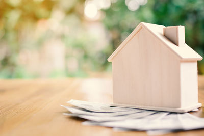 Close-up of model house on currencies over table