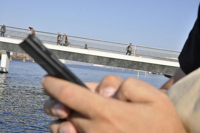Low angle view of people on bridge against sky