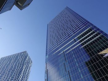 Low angle view of modern buildings against clear blue sky