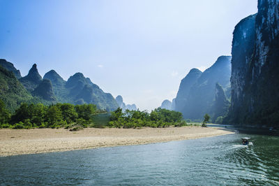 Scenic view of sea and mountains against sky