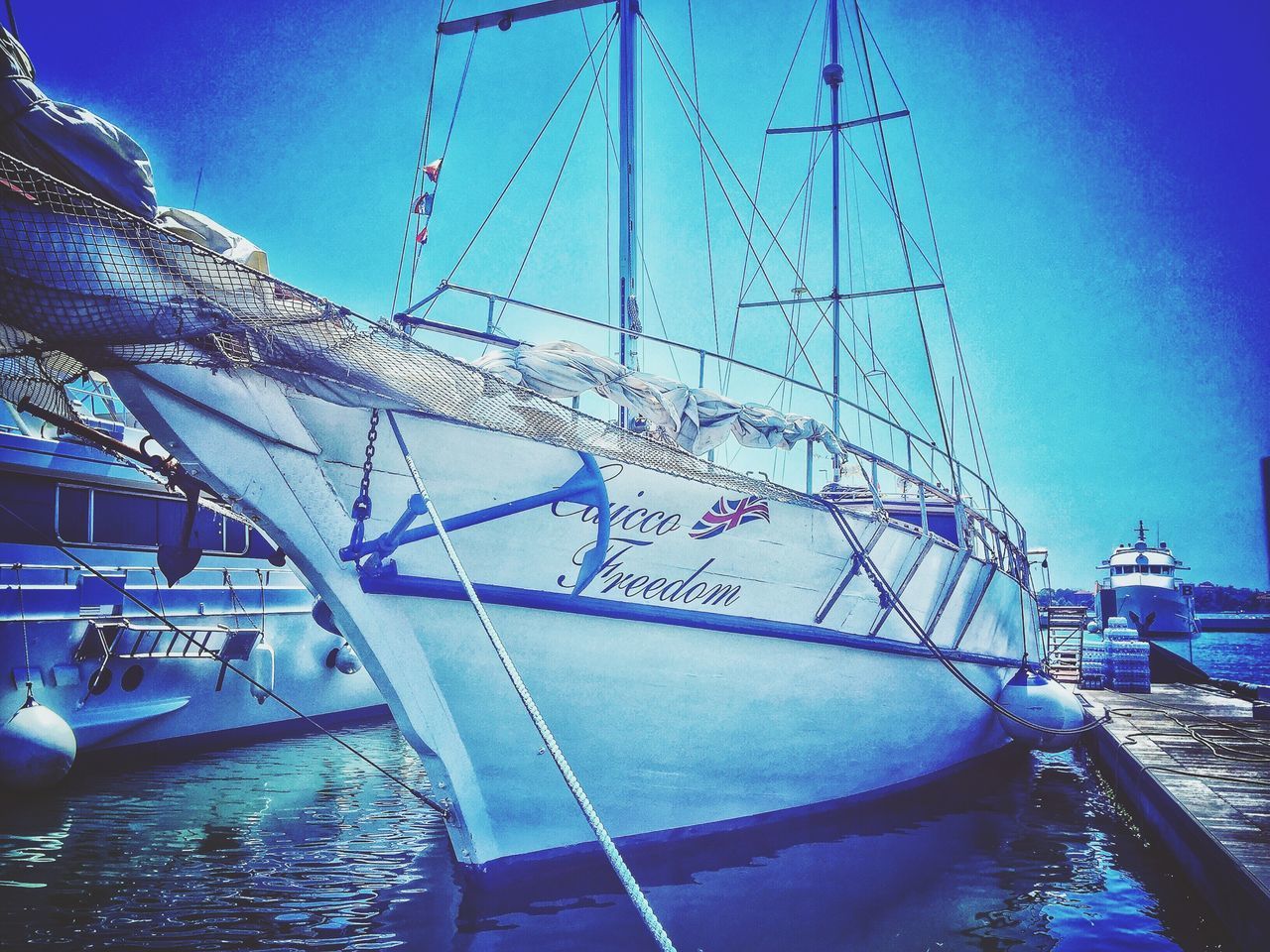 SAILBOATS MOORED IN SEA AGAINST SKY