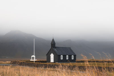 House on field against clear sky