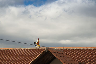 Low angle view of man working on roof of building
