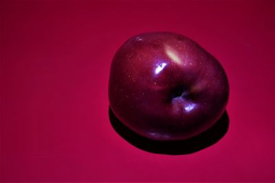 Close-up of apple against red background