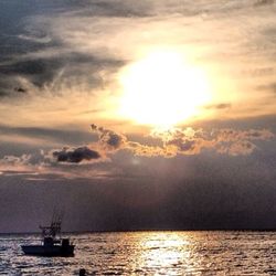 Boats in sea at sunset
