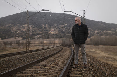 Adult man in warm clothing with railway in countryside. shot in castilla la mancha, spain