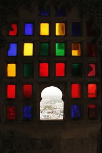 Low angle view of illuminated building seen through glass window