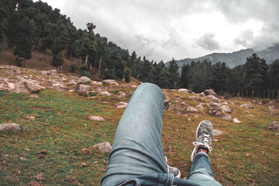 Low section of man relaxing on mountain