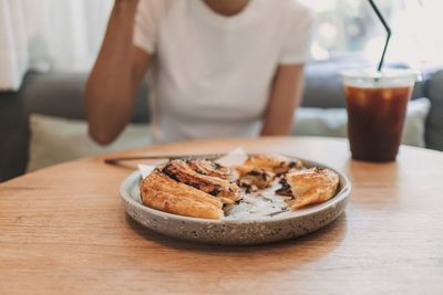 Midsection of woman having food on table
