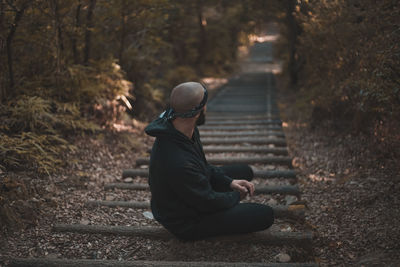 Side view of man sitting on staircase