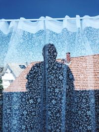 Woman standing by swimming pool against sky