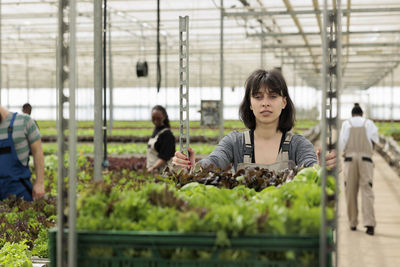 Portrait of young woman standing in greenhouse