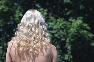 Rear view of shirtless woman against blurred background