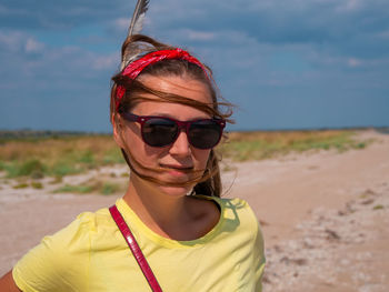 Smiling young boho woman feather in hair on beach european girl in red bandana tribal bohemian style