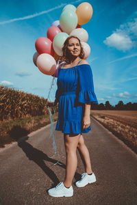 Full length of a smiling girl standing on road