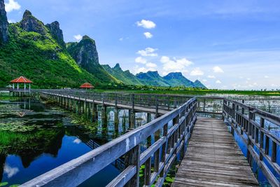 Jetty over lake with mountains against sky