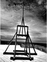 Empty swing at playground against sky