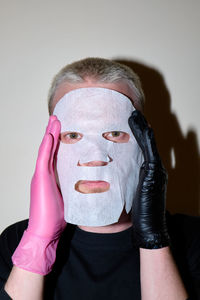 Portrait of woman wearing mask against white background