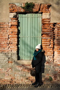 Woman standing on brick wall