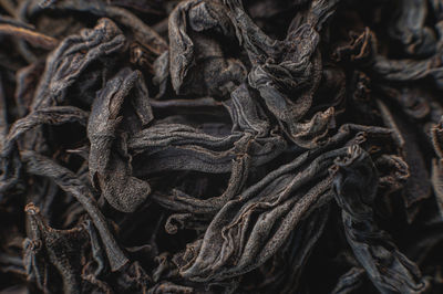 Black loose leaf tea as a background. texture of dry black tea leaves. dark background. extreme