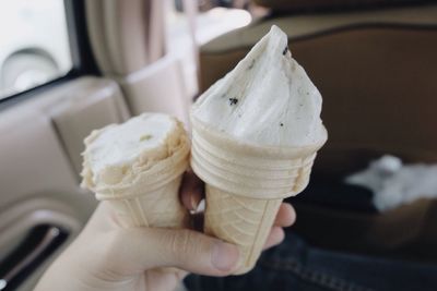 Close-up of hand holding ice cream in car