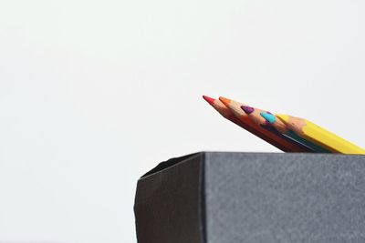 Close-up of colored pencils against white background