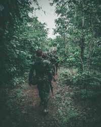 Rear view of people walking in forest