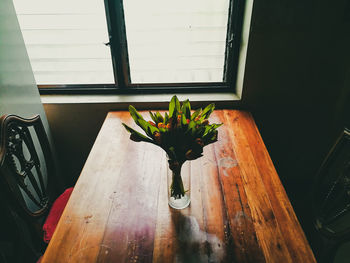 Flower vase on table by window at home