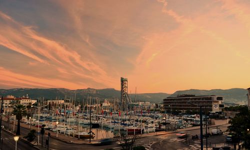 Boats moored at harbor during sunset