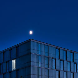 Low angle view of modern building against blue sky