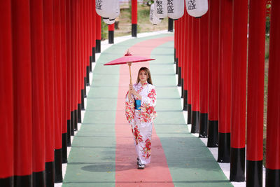 Woman standing against red wall