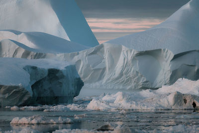 Iceberg in sea during sunset