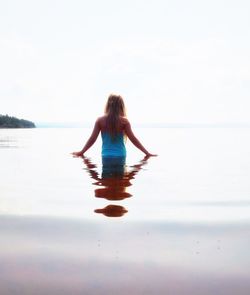 Rear view of woman standing on beach