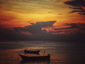 Fishing boat in sea against sky during sunset