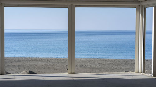 Scenic view of sea against clear sky seen through window