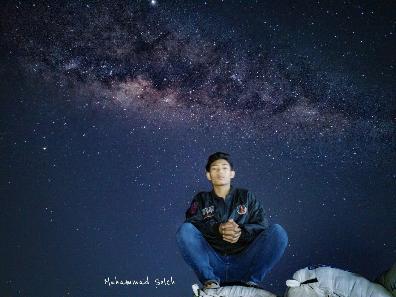 star - space, space, astronomy, night, one person, galaxy, sitting, young adult, sky, young men, infinity, nature, milky way, full length, leisure activity, casual clothing, constellation, outdoors, adult