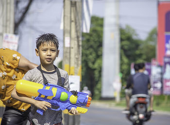 Portrait of boy holding squirt gun outdoors