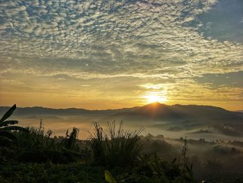 Scenic view of silhouette mountains against sky during sunset