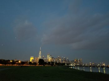 Illuminated buildings in city against sky at night