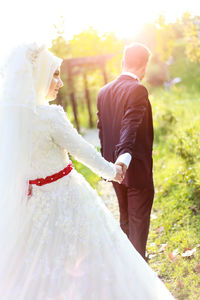 Rear view of couple holding hands