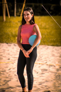 Portrait of young woman standing on field