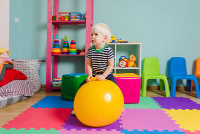 Cute boy playing with toy on table