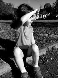 Full length of boy sitting on field