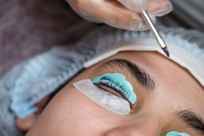 Close-up portrait of a woman on eyelash lamination procedure. 