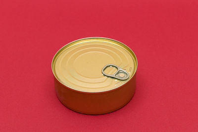 Unopened tin can with blank edge on red background